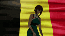 a woman in a green dress is standing in front of a red yellow and black flag