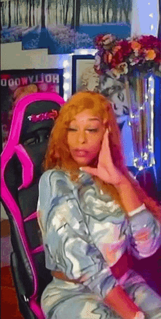 a woman sitting in a pink chair with a sign that says hollywood