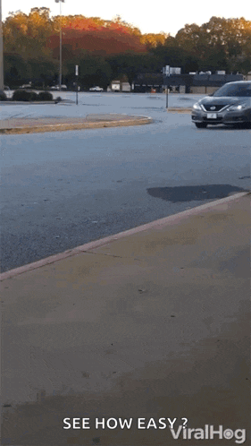 a car is driving down a parking lot with the words " see how easy " written on the bottom