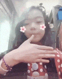 a girl with flowers on her face is making a face