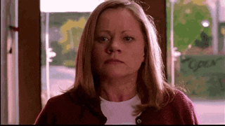 a woman in a red sweater is looking at the camera .