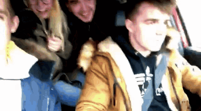 a group of people are sitting in a car and one of them is wearing an alpha industries hoodie