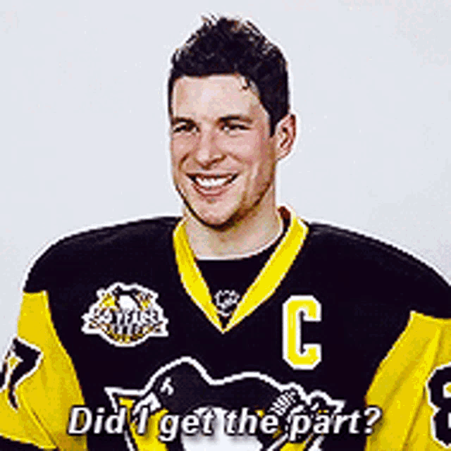 a hockey player wearing a black and yellow jersey with the letter c on it