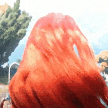 a close up of a person 's red hair against a blue sky