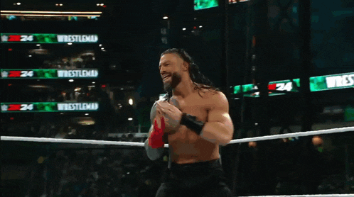 a man in a wrestling ring with a sign that says wrestlemania on it