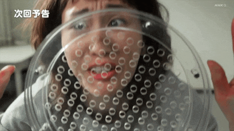 a woman is looking through a clear plastic plate with holes in it