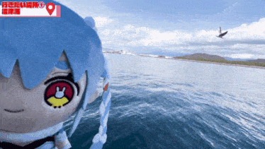 a stuffed animal with blue hair and a red eye is looking out over the ocean