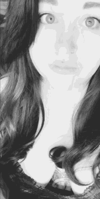 a black and white photo of a woman with long hair and blue eyes