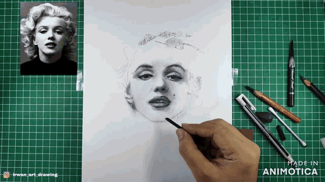 a person is drawing a picture of marilyn monroe on a cutting board