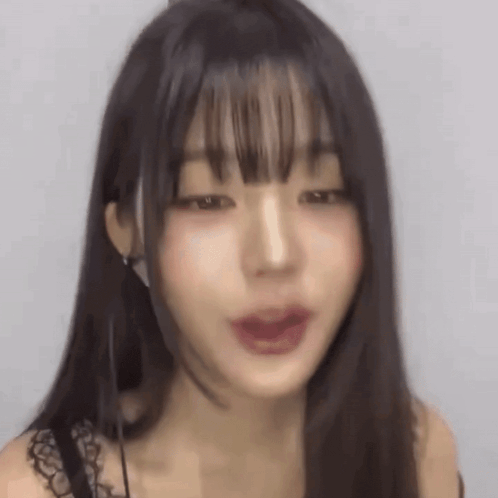 a close up of a woman 's face with long hair and bangs