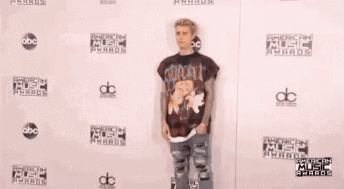 justin bieber is standing on the red carpet at the american music awards