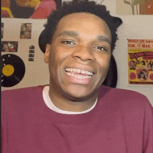 a man wearing a maroon shirt is smiling in front of a poster that says " women shoe bar "