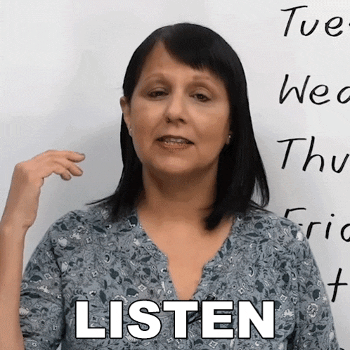 a woman stands in front of a white board with the words listen written on it