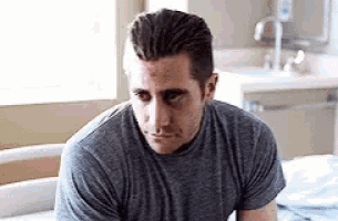 a man is sitting in a hospital bed looking at the camera .
