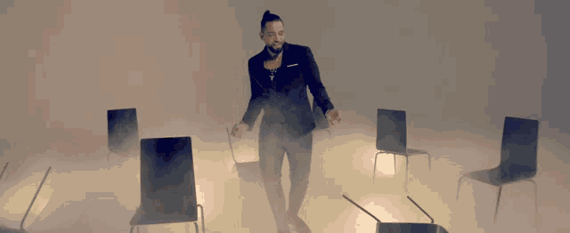 a man in a suit is standing in a room with chairs