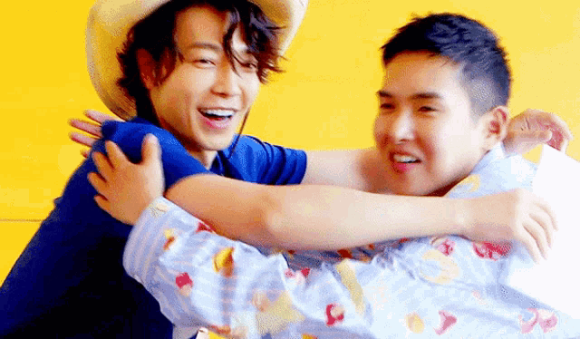 a man in a cowboy hat is hugging another man