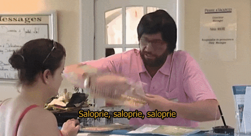 a man in a pink shirt is talking to a woman in front of a sign that says " messages "
