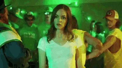 a woman in a white shirt is standing in front of a crowd of people .