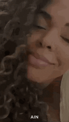 a close up of a woman 's face with her eyes closed and the words vai um beijin written on it .
