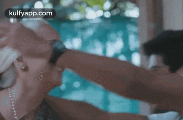 a man is putting a watch on a woman 's wrist while they are dancing .