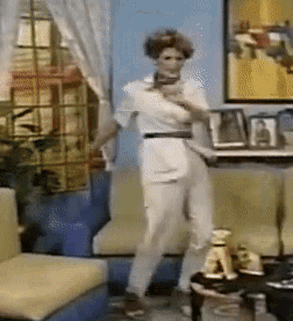 a woman is standing in a living room with a tray in her hand