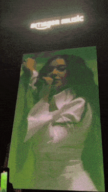 a woman singing in front of an amazon music banner