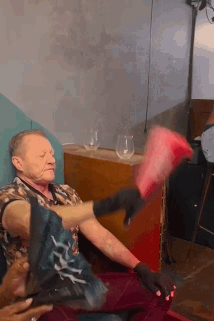a man wearing black gloves is being punched in the arm