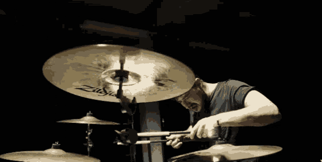 a man is playing a set of zildjian drums