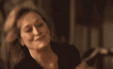 a woman is making a funny face with her eyes closed .