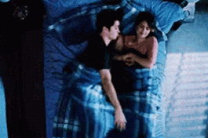 a man and a woman are laying on a bed .