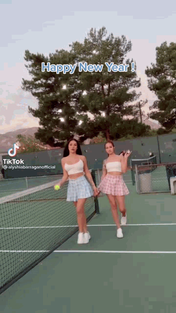 two women are holding tennis rackets on a tennis court with the caption happy new year