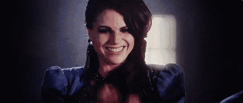 a woman in a blue dress is smiling with her hands behind her head .