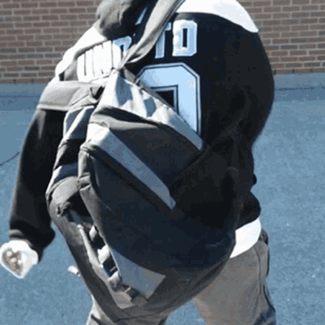 a person wearing a jersey that says united is carrying a duffel bag