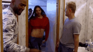 a man in a zebra print shirt is standing next to a woman in a crop top