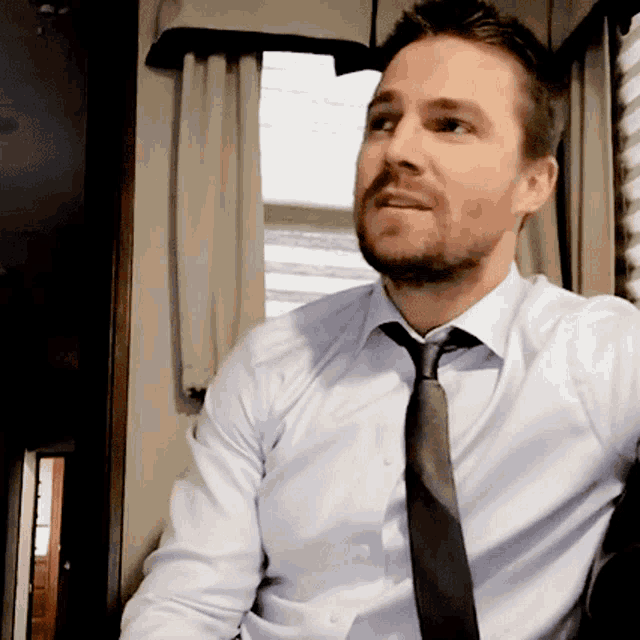 a man with a beard wearing a white shirt and a black tie