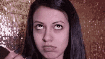 a woman is making a funny face while holding a toothpick in her mouth .