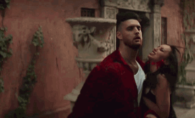 a man in a red jacket is being attacked by a woman .