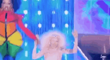 two women are dancing on a stage in front of a purple curtain .