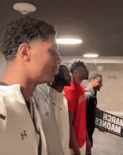 a group of young men are standing in a line and one of them is holding a sign that says high
