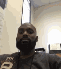 a man with a beard is sitting on a couch in a room .