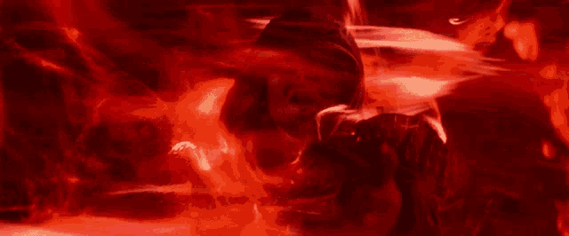 a man in a hooded sweatshirt is surrounded by red flames