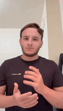 a man with a beard is clapping his hands in a room .