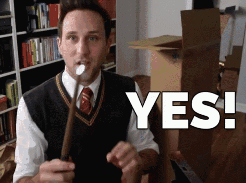 a man holding a wand with the word yes written on it