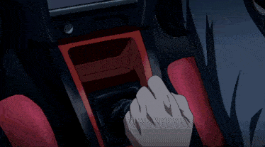 a man in a white shirt is driving a car with a steering wheel that has the letter o on it