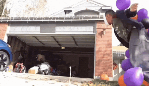 a man is jumping over balloons in front of a garage door