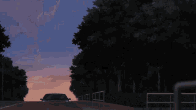 a car is driving down a dark road with trees in the background