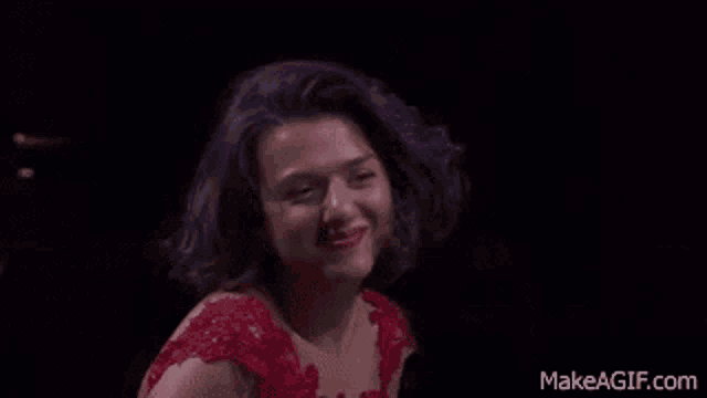 a woman in a red dress is making a funny face .