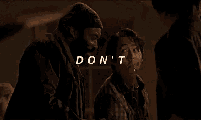 a man with a beard is holding a baby and the words do n't are above him