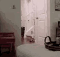 a blurred image of a bedroom with a bed and a staircase in the background