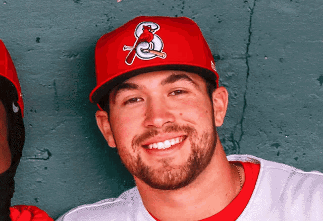 a man with a beard wearing a red hat with the letter s on it
